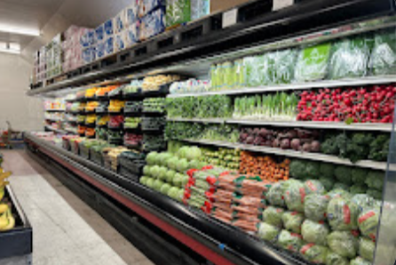 Refrigerated produce wall with leafy greens, radishes, carrots and cabbage